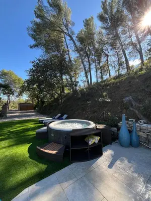 a patio with a table and chairs on the grass at Maisonnette climatisée in Aix-en-Provence