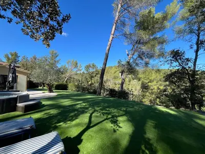 a green yard with a bench and trees at Maisonnette climatisée in Aix-en-Provence