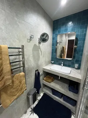 a bathroom with a sink and a mirror and blue tiles at Maisonnette climatisée in Aix-en-Provence