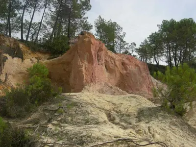 a large rock formation on a hill with trees at Location avec piscine Roussillon LS2-91 in Roussillon