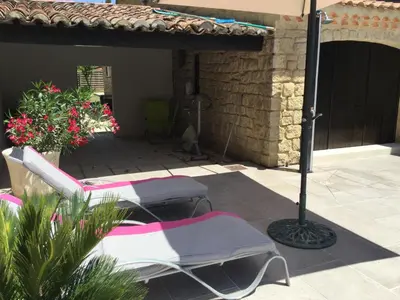 two lawn chairs and an umbrella on a patio at Maison avec piscine privative Taillades Luberon LS2-281 in Les Taillades