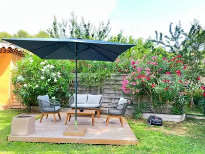a patio with a table and chairs and an umbrella at The Maisonnette in the pines in Ventabren
