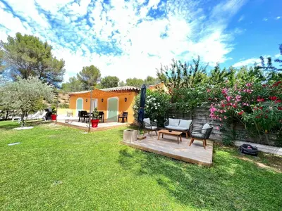 a backyard with a wooden deck and a house at The Maisonnette in the pines in Ventabren