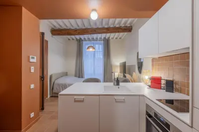 a kitchen with a sink and a room with a bed at Appartement Belle Lettre 1 in Aix-en-Provence