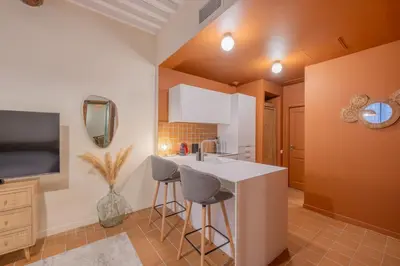 a kitchen with a sink and a counter with stools at Appartement Belle Lettre 1 in Aix-en-Provence