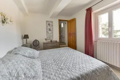 a white bedroom with a bed and a window at Chambre d'hôtes le Jardinage in Cabrières-dʼAvignon