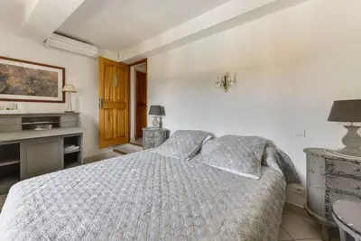 a white bedroom with a bed and a tv at Chambre d'hôtes le Jardinage in Cabrières-dʼAvignon