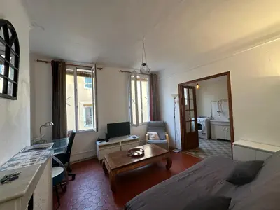 a bedroom with a bed and a living room with a table at Chez Monique - Appartement T2 au cœur du centre ville historique - proche Mairie et Cardeurs in Aix-en-Provence