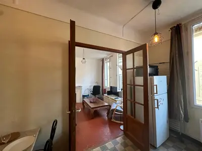 a kitchen with a door open to a living room at Chez Monique - Appartement T2 au cœur du centre ville historique - proche Mairie et Cardeurs in Aix-en-Provence