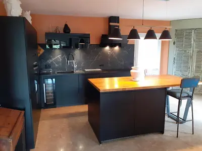 a kitchen with blue cabinets and a wooden counter top at Au pied du Luberon in Les Taillades
