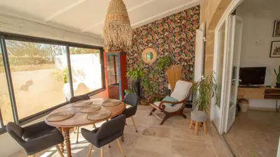 a living room with a table and chairs at Au pied du Luberon in Les Taillades