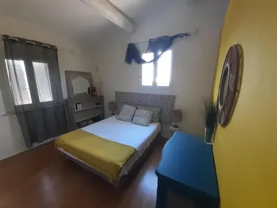 a small bedroom with a bed and a window at Au pied du Luberon in Les Taillades