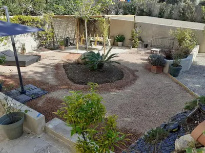 a garden with a bunch of plants and an umbrella at Au pied du Luberon in Les Taillades