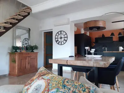 a living room with a wooden table and a couch at Au pied du Luberon in Les Taillades