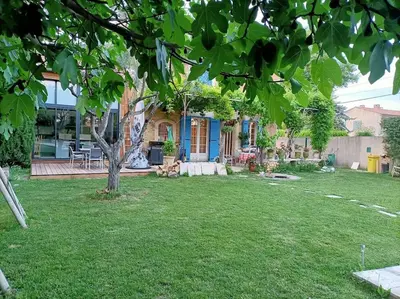 a yard with a house with a tree in it at Superbe appartement neuf au cœur de la Provence. in Entraigues-sur-la-Sorgue
