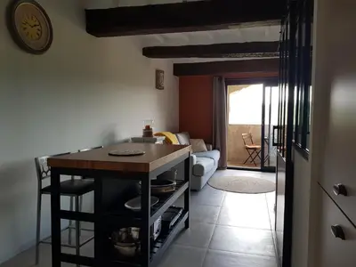 a kitchen with a table and a living room at Le Cosy Luberon - Viens in Viens