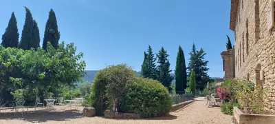 a garden with tables and trees and a building at Le Cosy Luberon - Viens in Viens