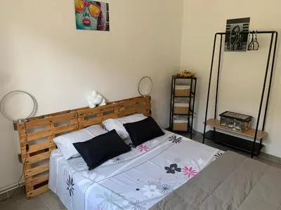 a bedroom with a wooden bed with two pillows at Entre ciel et terre in Le Thor