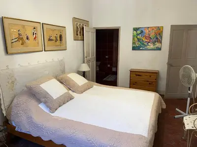 a bedroom with a white bed and pictures on the wall at Chez Christel in Apt