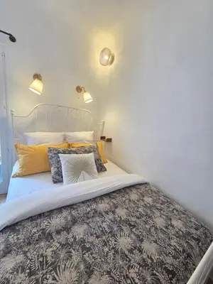 a large white room with a bed and a counter at Le Studio des Fontêtes Climatisé in Aix-en-Provence