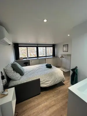 a bedroom with a bed and a large window at L'Olivier - Joli duplex au cœur du centre ville à 2 pas de la Rotonde Mirabeau et des allées Provençales in Aix-en-Provence
