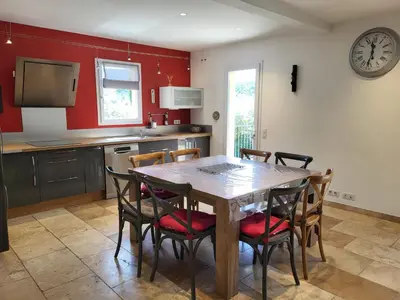 a kitchen with a wooden table and chairs at L'escapade provençale in Lioux