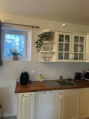 a kitchen with white cabinets and a sink and a window at Bastidon de Gordes in Gordes