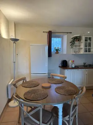 a kitchen with a table with four chairs and a refrigerator at Bastidon de Gordes in Gordes