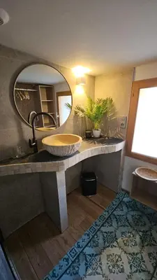 a bathroom with a large sink and a mirror at Cocon Authentique de Roussillon in Roussillon