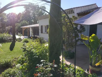 a garden with an archway in front of a house at Au Bonheur et Liberté in Meyrargues