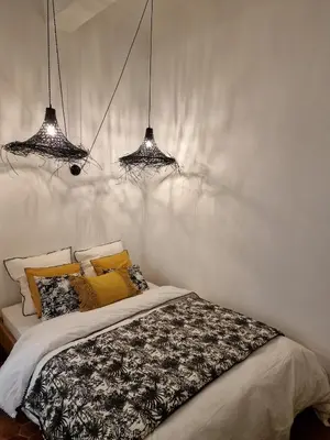 a bedroom with two chandeliers above a bed at Appartement Cosy Hyper Centre Climatisé - Rue Bédarrides in Aix-en-Provence