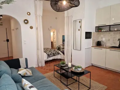 a living room with a blue couch and a table at Appartement Cosy Hyper Centre Climatisé - Rue Bédarrides in Aix-en-Provence