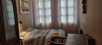 a small bedroom with a bed and a table at Appartement centre ville Hôtel Particulier in Carpentras