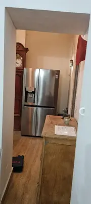 a kitchen with a stainless steel refrigerator in a room at Appartement centre ville Hôtel Particulier in Carpentras