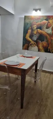 a table with two chairs and a painting on the wall at Appartement centre ville Hôtel Particulier in Carpentras