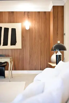 a bedroom with wood paneling and a table and two beds at Hôtel Bellegarde by Viktor in Aix-en-Provence