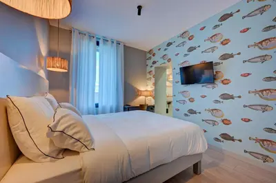 a bedroom with a bed and a wall with fish on it at Hôtel Bellegarde by Viktor in Aix-en-Provence