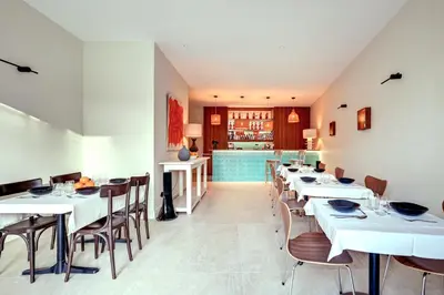 a dining room with white tables and chairs at Hôtel Bellegarde by Viktor in Aix-en-Provence