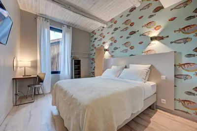 a bedroom with a large bed with a fish wall at Hôtel Bellegarde by Viktor in Aix-en-Provence
