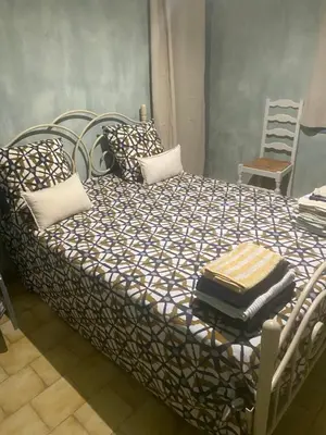 a bed with a black and white comforter and a chair at Villa Provençale climatisée près Aix en Provence Piscine securisée alarme in Ventabren