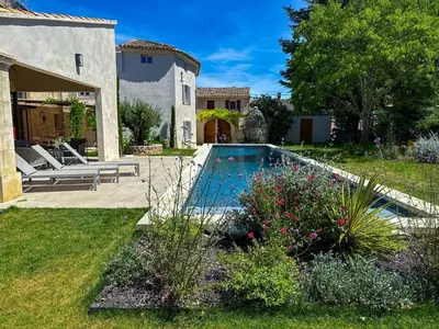a backyard with a swimming pool and a house at La Magnanerie 1818 villa de prestige 5 étoiles Luberon in Saint-Saturnin-les-Apt