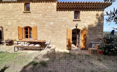 a stone building with a door and a bench in front at Noceta in Miramas