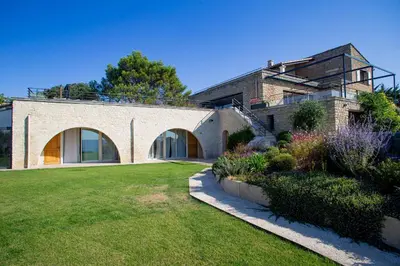 a large brick house with a green yard at 8-bedroom luxury villa with pool in Gordes