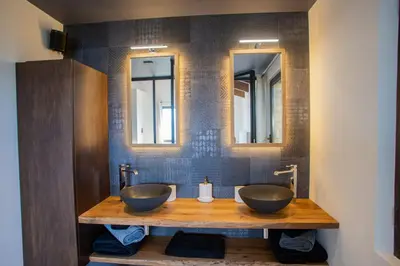 two sinks in a bathroom with two mirrors at 8-bedroom luxury villa with pool in Gordes