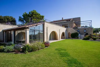 a brick house with a lawn in front of it at 8-bedroom luxury villa with pool in Gordes