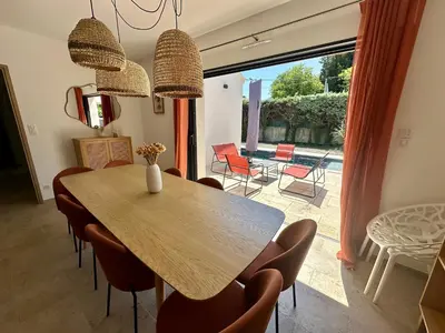 a dining room with a wooden table and chairs at Villa Provençale in Le Thor