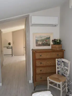 a hallway with a dresser and a chair in a room at L'ancien poulailler- The Old Hen House in Saint-Saturnin-les-Apt