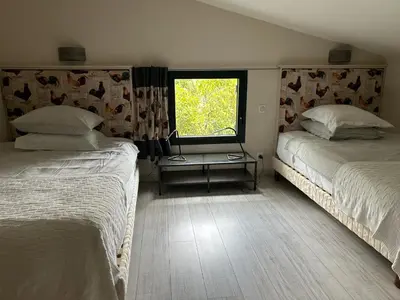 two beds in a room with a window at L'ancien poulailler- The Old Hen House in Saint-Saturnin-les-Apt