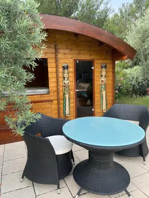 a patio with a table and chairs in front of a cabin at Appel du Luberon in Mérindol