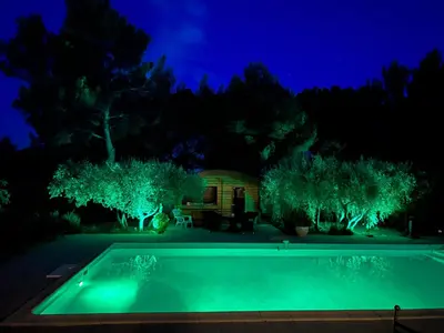 a swimming pool at night with green lights at Appel du Luberon in Mérindol